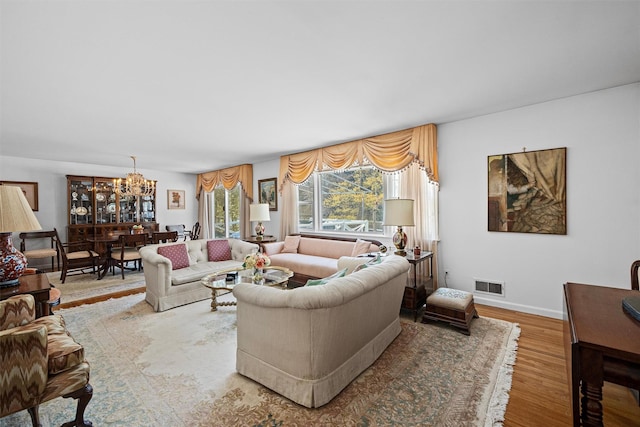 living room with hardwood / wood-style flooring and a notable chandelier