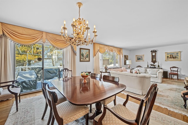 dining space with an inviting chandelier and light hardwood / wood-style floors