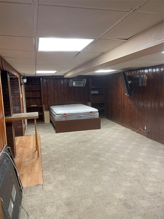 recreation room featuring a paneled ceiling, wooden walls, and carpet floors