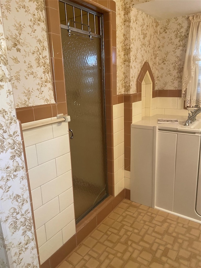 bathroom featuring an enclosed shower and tile walls