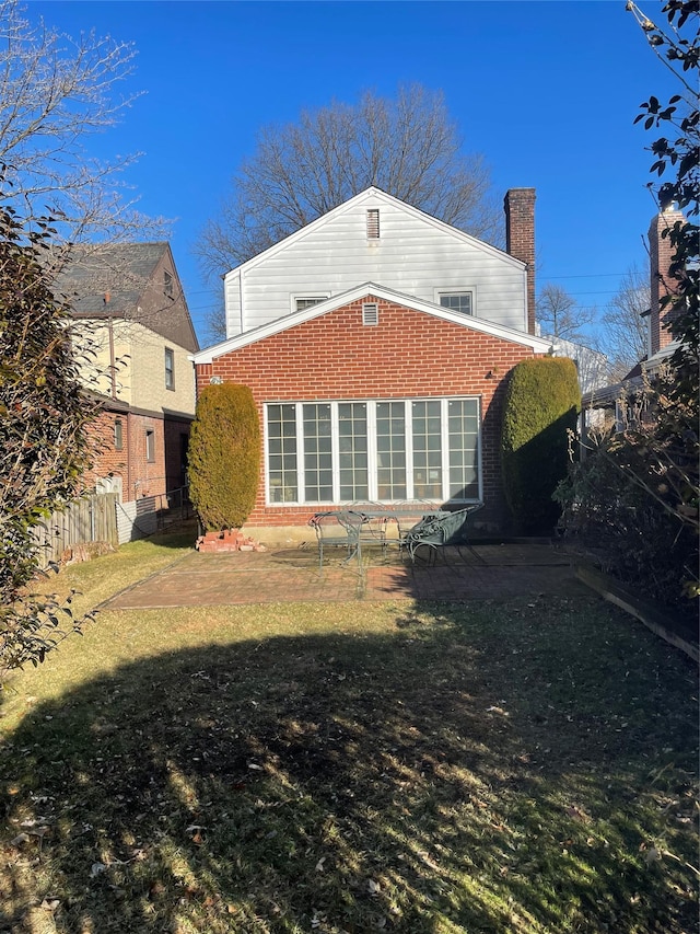 back of house featuring a lawn and a patio