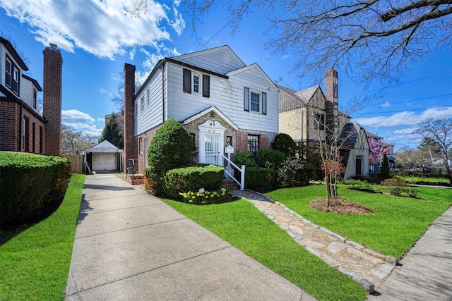 47-44 Glenwood St, Little Neck, NY 11362 - view of front of home with brick siding, a front lawn, a detached garage, and an outbuilding
