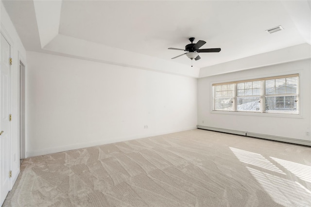 carpeted empty room with ceiling fan, a baseboard radiator, and a raised ceiling