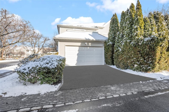 snow covered property featuring a garage