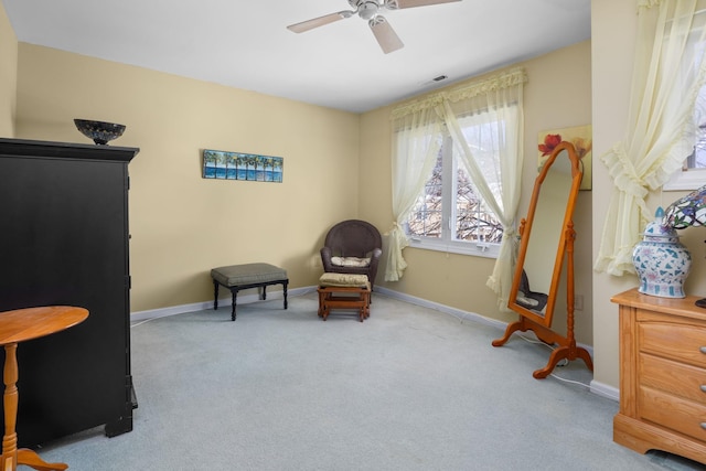 living area featuring light carpet and ceiling fan