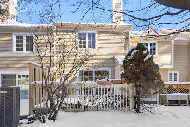 snow covered house featuring central AC