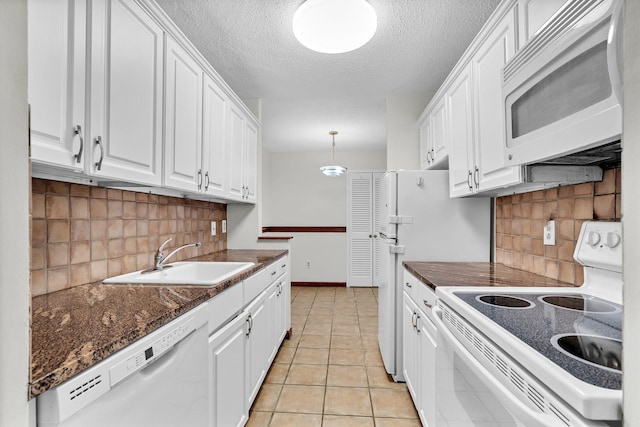 25 Rockledge Ave Unit 906W, White Plains, NY 10601 - kitchen featuring a sink, white appliances, dark countertops, and white cabinets