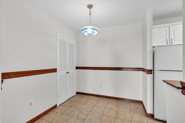 25 Rockledge Ave Unit 906W, White Plains, NY 10601 - unfurnished dining area with light tile patterned floors, baseboards, and a textured ceiling
