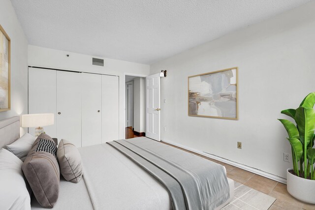25 Rockledge Ave Unit 906W, White Plains, NY 10601 - bedroom featuring light tile patterned flooring, visible vents, a closet, and a textured ceiling