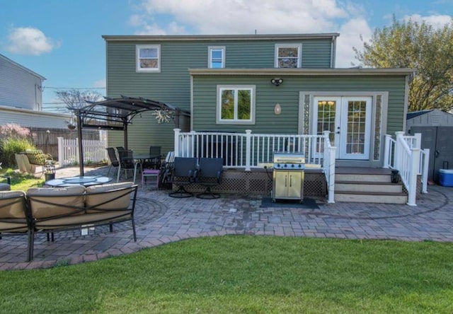 back of property with a storage shed, a patio area, a lawn, a pergola, and a wooden deck