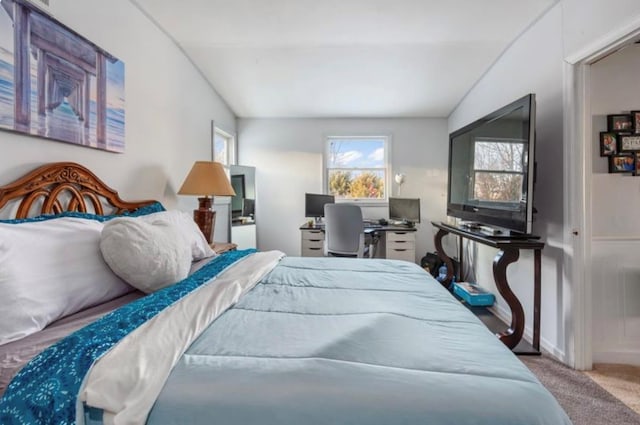 bedroom featuring vaulted ceiling and carpet