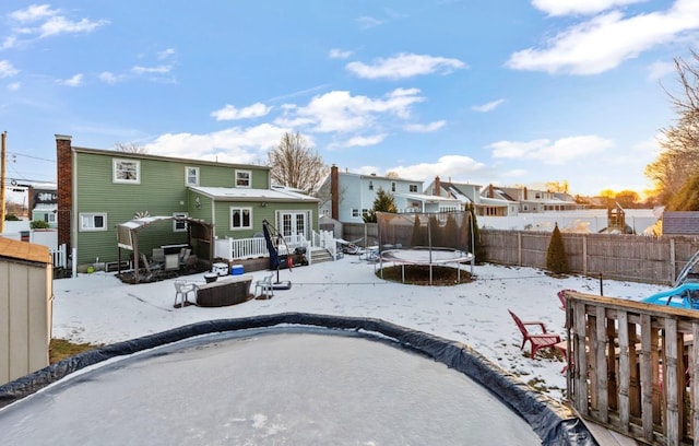 snow covered property featuring a deck and a trampoline