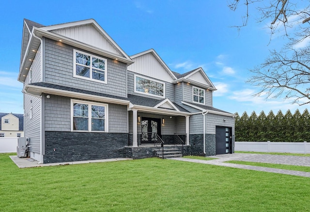 view of front facade featuring a porch, a garage, and a front yard