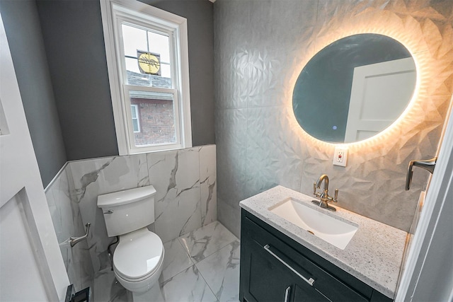 bathroom featuring vanity, toilet, and tile walls