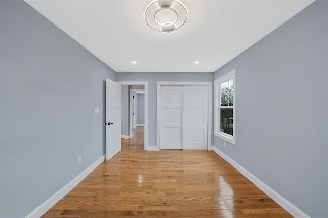 unfurnished bedroom with a closet and light wood-type flooring