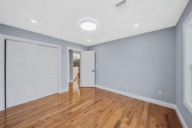 unfurnished bedroom with light hardwood / wood-style floors and a closet