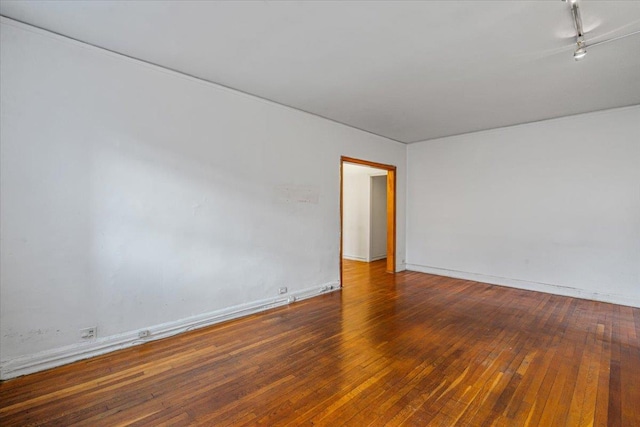 unfurnished room featuring track lighting and wood-type flooring