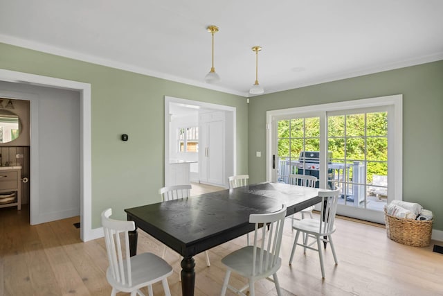 dining area with ornamental molding and light wood-type flooring