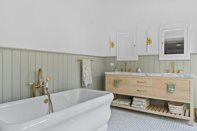 bathroom with tile patterned floors, a bathing tub, and vanity