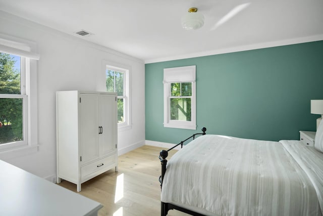 unfurnished bedroom featuring crown molding and light hardwood / wood-style flooring