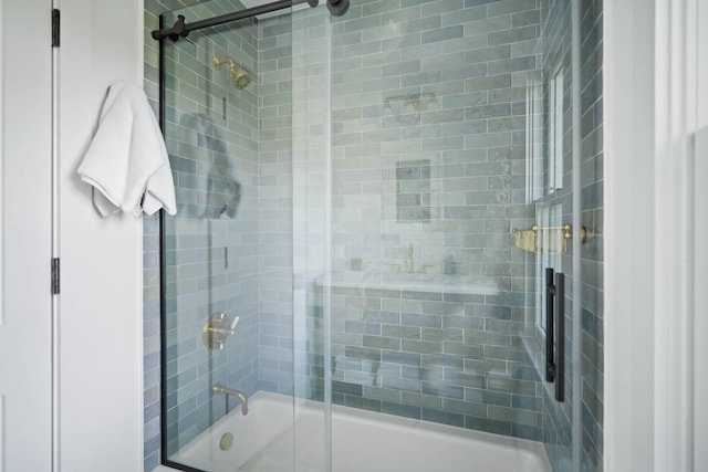 bathroom featuring combined bath / shower with glass door