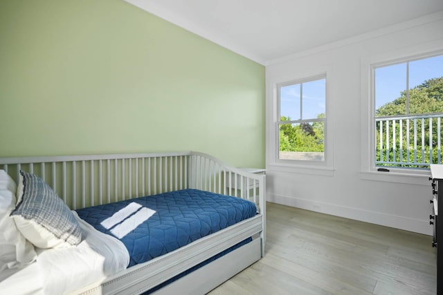 bedroom featuring crown molding and light hardwood / wood-style floors