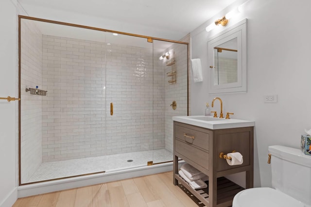 bathroom featuring an enclosed shower, vanity, hardwood / wood-style floors, and toilet