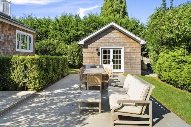 view of patio / terrace with an outdoor living space, an outbuilding, and french doors