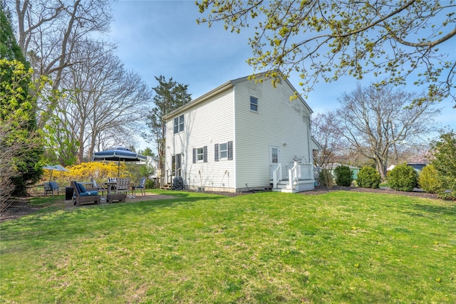 rear view of property featuring a lawn and a patio