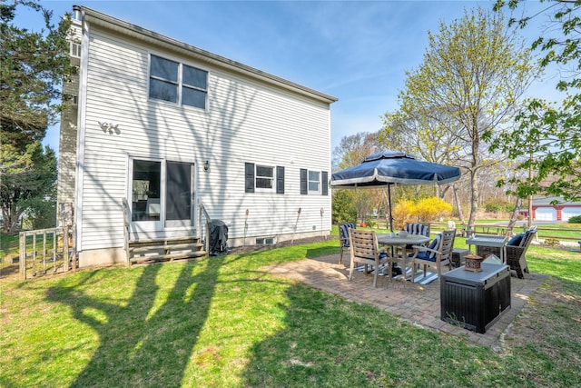 rear view of property with entry steps, a lawn, and a patio