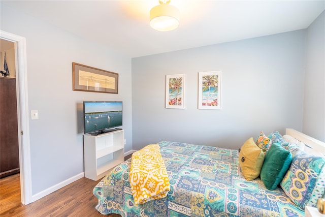 bedroom featuring baseboards and wood finished floors