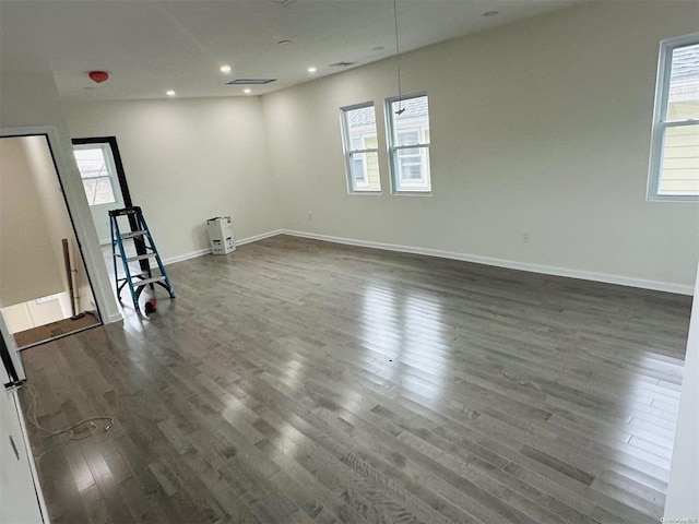 empty room with dark wood-type flooring and a healthy amount of sunlight