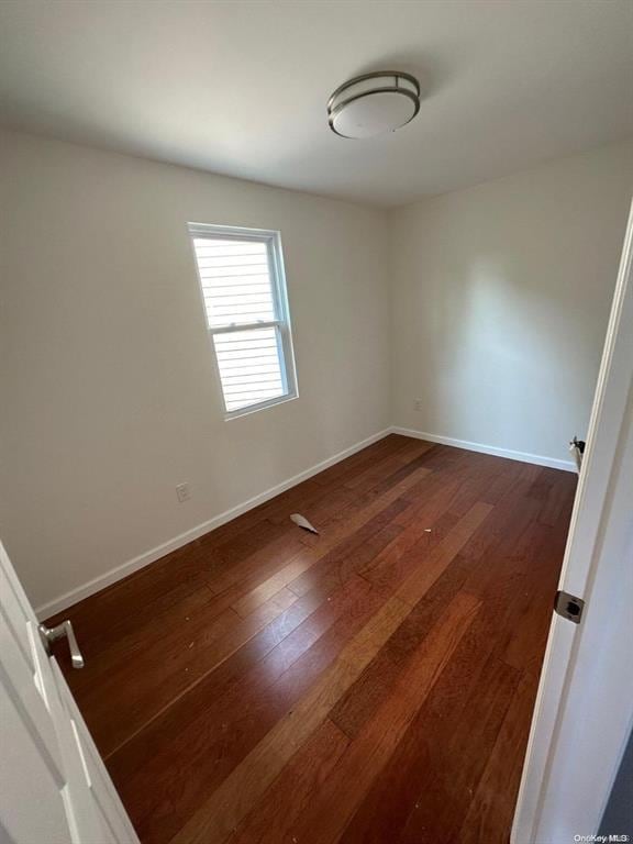 unfurnished room with dark hardwood / wood-style floors