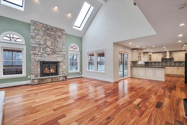 unfurnished living room featuring a skylight, light wood finished floors, and a wealth of natural light