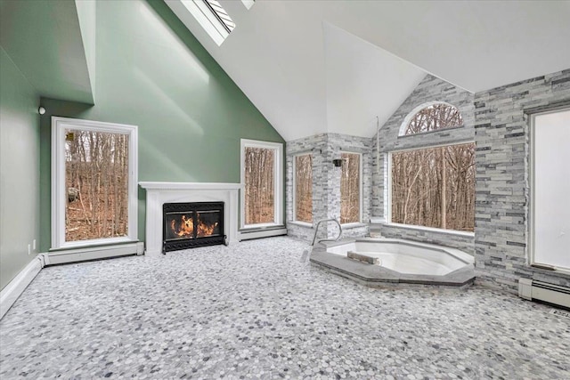 interior space with a baseboard heating unit, a glass covered fireplace, and lofted ceiling