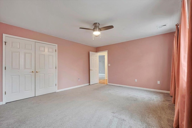unfurnished bedroom with ceiling fan, a closet, visible vents, carpet flooring, and baseboards