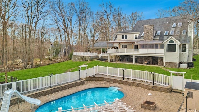 view of swimming pool featuring a yard, a fenced backyard, a water slide, a patio area, and a fenced in pool