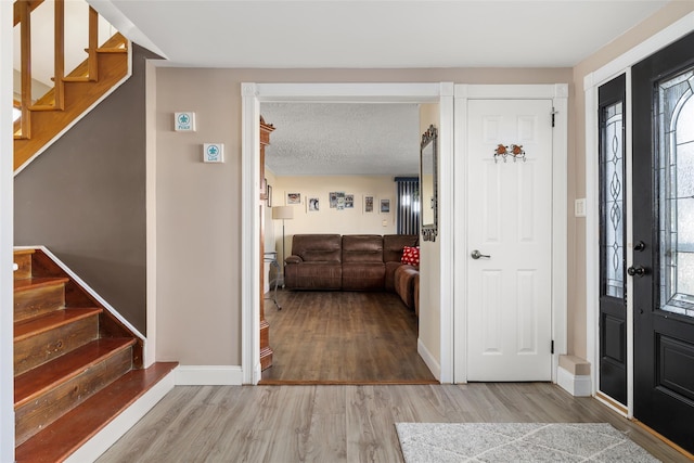 foyer with hardwood / wood-style floors and a textured ceiling