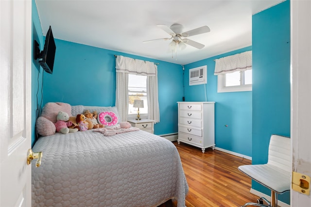 bedroom with hardwood / wood-style flooring, ceiling fan, a wall mounted air conditioner, and a baseboard heating unit