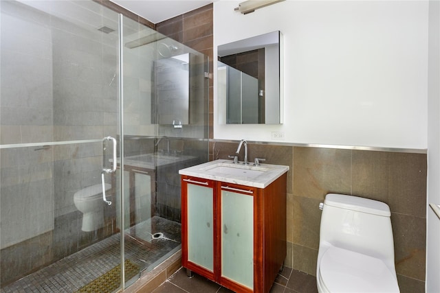 bathroom with walk in shower, vanity, toilet, and tile walls