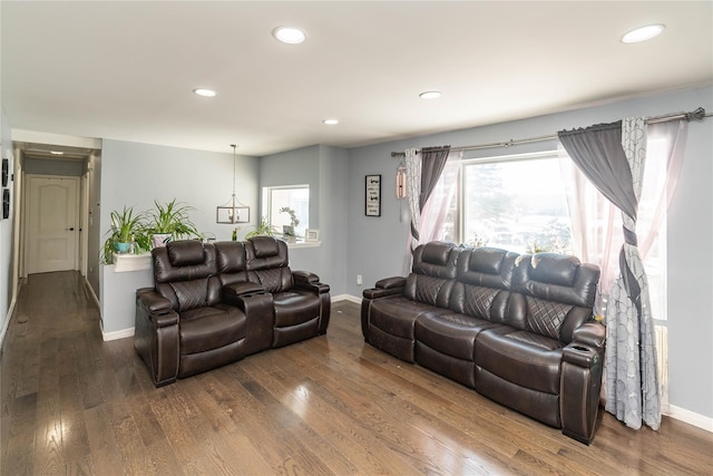 living room featuring dark wood-type flooring and plenty of natural light