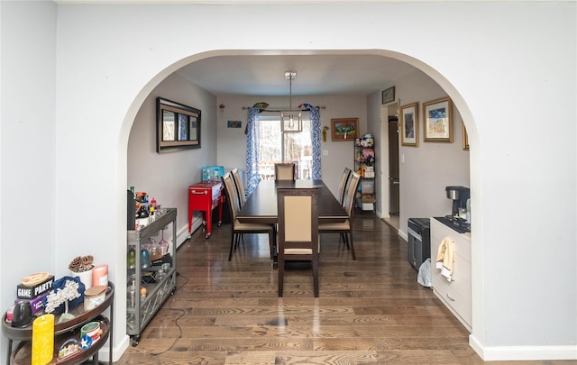 dining area with baseboard heating and dark hardwood / wood-style flooring