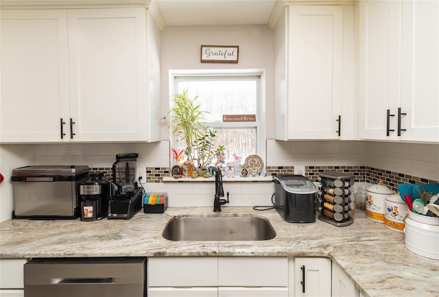 kitchen featuring white cabinetry, sink, light stone countertops, and dishwasher