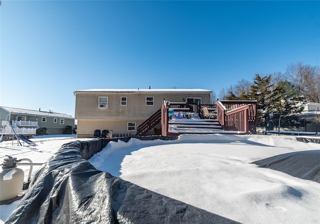 snow covered rear of property featuring a deck