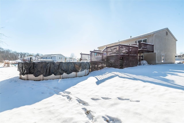 yard layered in snow with a wooden deck