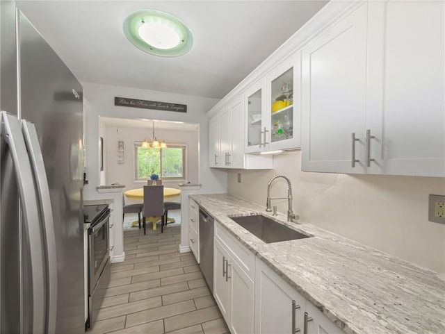 kitchen with white cabinetry, stainless steel appliances, and sink