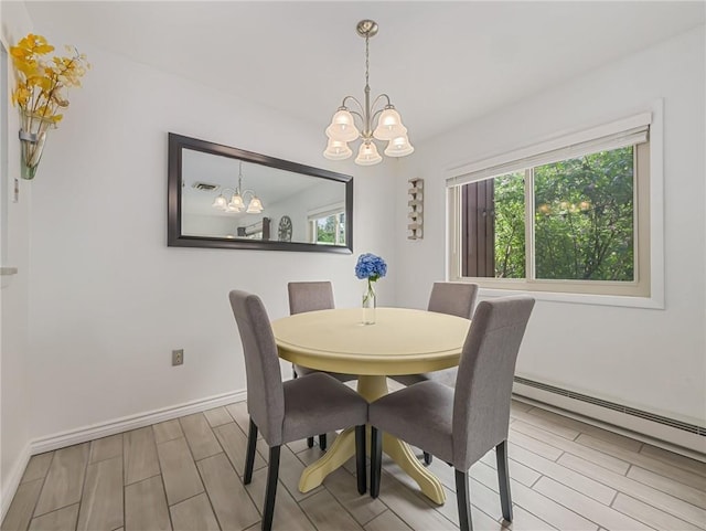 dining room with a baseboard heating unit and a chandelier