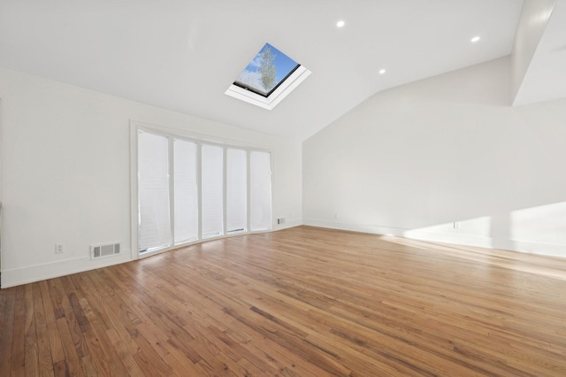 interior space featuring light hardwood / wood-style floors and vaulted ceiling with skylight