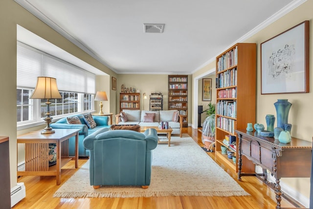 living room featuring ornamental molding, hardwood / wood-style floors, and baseboard heating