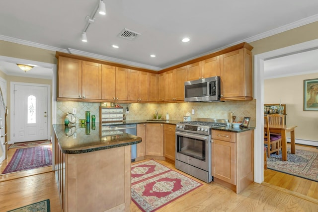 kitchen featuring sink, crown molding, appliances with stainless steel finishes, backsplash, and light wood-type flooring